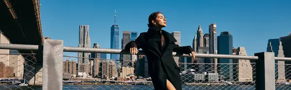 A young woman dances on the Brooklyn Bridge, facing the Manhattan skyline. — Stock Photo