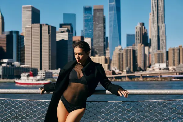 Una mujer vestida de negro baila en una barandilla en Nueva York. - foto de stock