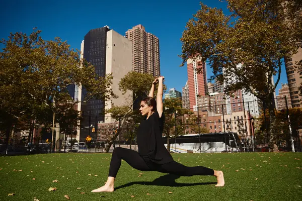 A young woman dances on a green lawn in New York City. — Stock Photo