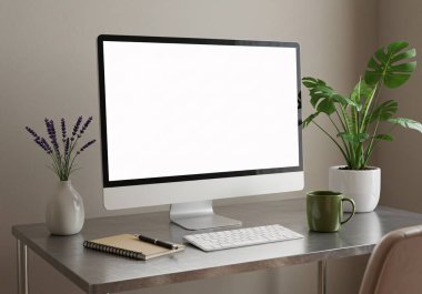 Bitkiler, not defterleri ve kupaları olan boş bir bilgisayar ekranı içeren minimalist çalışma alanı, tasarım veya uzak çalışma ortamı için mükemmeldir..