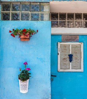 Pencereli ve çiçekli mavi duvar