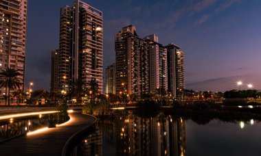 Yüksek binalar suya yansıyor.