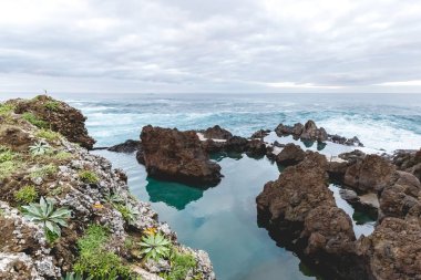 Portekiz 'in Madeira adasında, Porto Moniz' de Atlantik Okyanusu 'nun önündeki doğal yüzme havuzu.