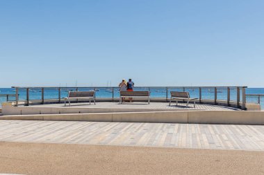 Les Sables d Olonne, Fransa - 10 Temmuz 2022: İnsanlar güneşli bir yaz gününde (Grande Plage) büyük plajda geziniyorlar.