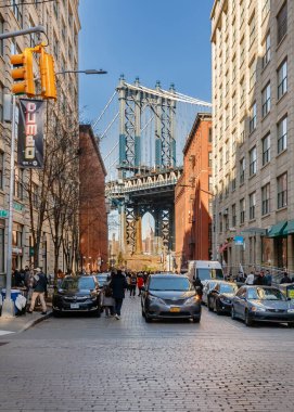Brooklyn, New York, ABD - 11 Şubat 2023: Dumbo Mahallesi 'nden Manhattan Köprüsü' nün altında insanların kış günü yürüdüğü tuğla binaların manzarası