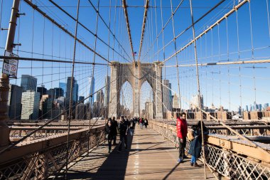 Brooklyn, New York, ABD - 11 Şubat 2023: Brooklyn Köprüsü ve Manhattan, insanların kış günü yürüdüğü Doğu Nehri manzarası.