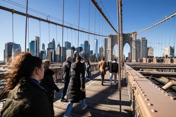 Brooklyn, New York, ABD - 11 Şubat 2023: Brooklyn Köprüsü ve Manhattan, insanların kış günü yürüdüğü Doğu Nehri manzarası.