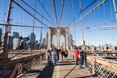 Brooklyn, New York, ABD - 11 Şubat 2023: Brooklyn Köprüsü ve Manhattan, insanların kış günü yürüdüğü Doğu Nehri manzarası.