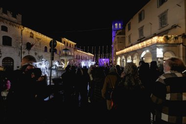 Assisi, İtalya - 1 Ocak 2024: İnsanlar yılbaşı gecesi havai fişekler ve konserle şehrin ana meydanında parti yapıyorlar.