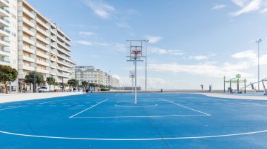 Povoa de Varzim, Porto, Portekiz - 22 Ekim 2020: bir sonbahar günü deniz kenarında basketbol sahası ve çocuk oyun parkı