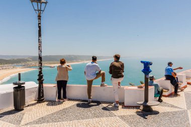 Nazare, Portugal - May 28, 2024: Tourists looking at Nazare Bay on a sunny spring day clipart