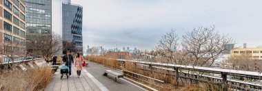 Manhattan, New York, ABD - 16 Şubat 2024: Gri bir kış gününde insanlar tarafından ziyaret edilen tipik binalarıyla Hight Line manzarası