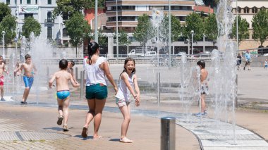 Bilbao, İspanya - 19 Temmuz 2016: Sıcak bir yaz gününde şehir merkezindeki bir çeşmede oynayan çocuklar