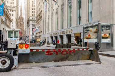 Wall Street, Manhattan, New York, USA - February 12, 2023: Burglar protection and security guards in front of the Trump Building where people are walking on a winter day clipart