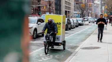 Manhattan, New York, ABD - 16 Şubat 2023: Gri bir kış gününde şehir merkezinde bisikletli kurye