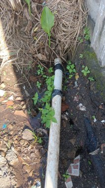 Siyah bantlı beyaz bir PVC boru kısmen duruyor.