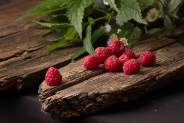 Ahşap zemin üzerinde kırmızı ahududu ve nane yaprakları