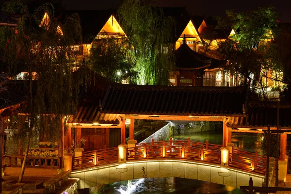 夜に美しい家の背景を持つ中国スタイルの橋 — ストック写真