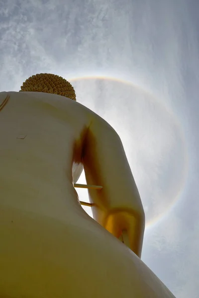 Sun halo on blue sky over a Buddha image