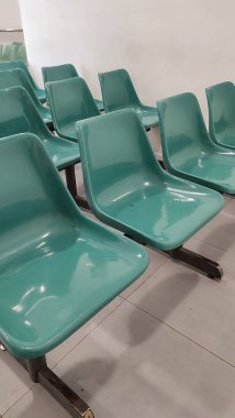 Kamu alanlarında bekleyen insanlar, örneğin hastane, tren istasyonu, kamu hizmetleri bürosu gibi yeşil plastik sandalyeler kullanılıyor.