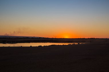 Güneş Fayoum 'da çölle çevrili sihirli göle batıyor. Güneş batıyor.