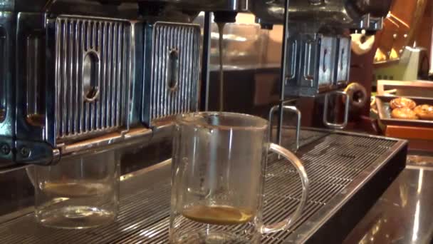 ガラスマグカップにカプチーノを注ぐコーヒーマシンのビデオ映像は フィールドの浅い深さで選択的な焦点です — ストック動画