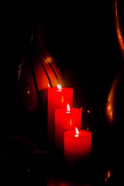 Red romantic candle light in a black background, shot is selective focus with shallow depth of field