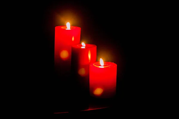 Red romantic candle light in a black background, shot is selective focus with shallow depth of field