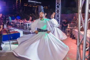 Mevlevi, Ramazan 'da bir çadırda dansçılar dairenin etrafında dönerler. Fotoğraf, yüzeysel alan derinliğiyle seçici bir odak noktasıdır. 22 Mayıs 2018 'de Kahire Mısır' da çekildi.