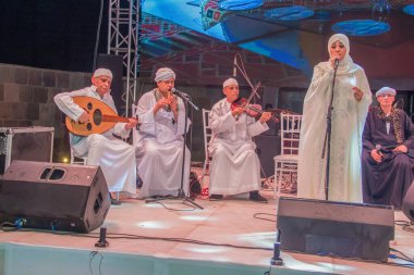 Ramazan çadırı müzikal gösterisi. Şarkıcı ve müzik grubu sahnede. Fotoğraf, yüzeysel alan derinliğiyle seçici bir odak noktasıdır. 22 Mayıs 2018 'de Kahire Mısır' da çekildi. 