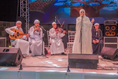 Ramazan çadırı müzikal gösterisi. Şarkıcı ve müzik grubu sahnede. Fotoğraf, yüzeysel alan derinliğiyle seçici bir odak noktasıdır. 22 Mayıs 2018 'de Kahire Mısır' da çekildi. 