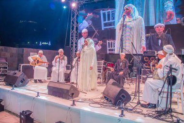 Ramazan çadırı müzikal gösterisi. Şarkıcı ve müzik grubu sahnede. Fotoğraf, yüzeysel alan derinliğiyle seçici bir odak noktasıdır. 22 Mayıs 2018 'de Kahire Mısır' da çekildi. 