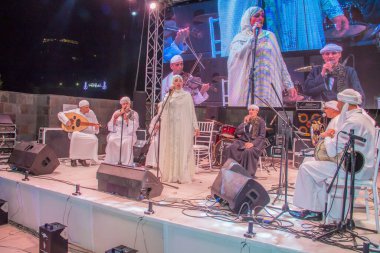 Ramazan çadırı müzikal gösterisi. Şarkıcı ve müzik grubu sahnede. Fotoğraf, yüzeysel alan derinliğiyle seçici bir odak noktasıdır. 22 Mayıs 2018 'de Kahire Mısır' da çekildi. 