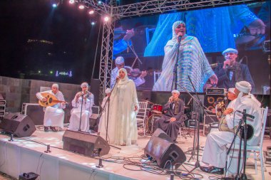 Ramazan çadırı müzikal gösterisi. Şarkıcı ve müzik grubu sahnede. Fotoğraf, yüzeysel alan derinliğiyle seçici bir odak noktasıdır. 22 Mayıs 2018 'de Kahire Mısır' da çekildi. 