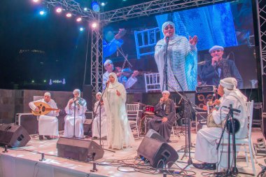 Ramazan çadırı müzikal gösterisi. Şarkıcı ve müzik grubu sahnede. Fotoğraf, yüzeysel alan derinliğiyle seçici bir odak noktasıdır. 22 Mayıs 2018 'de Kahire Mısır' da çekildi. 