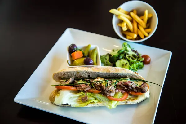 Yemek Fotoğrafları, biftekli sandviç, sebzeli, salatalı ve pomfretli fotoğraf, sığ alan derinliğinde seçici bir odak noktasıdır. Kahire 'deki Sheraton Oteli' nde çekildi.