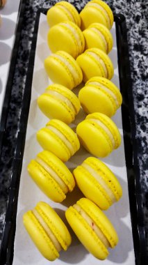 Makarnalar tatlı yemek fotoğrafçılığı, limon ve tutku meyvesi, sarı renk, beyaz kağıt, siyah arkaplan, pasta, fırın, çekim Kahire Mısır 'da sığ alan derinliği ile seçici bir odak noktasıdır.