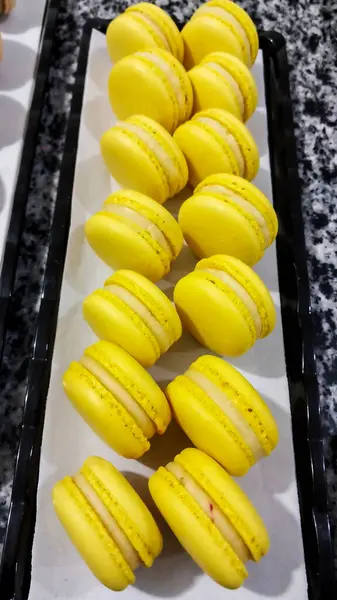 Makarnalar tatlı yemek fotoğrafçılığı, limon ve tutku meyvesi, sarı renk, beyaz kağıt, siyah arkaplan, pasta, fırın, çekim Kahire Mısır 'da sığ alan derinliği ile seçici bir odak noktasıdır.