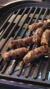 Full HD 1080p 30fps dikey video görüntüsü, ızgara Mısır kebabı ve Kofta elektrikli ızgara, seçici odak, sığ alan derinliği, HACE sergisi 2024 'te çekilen makaralar, 3 Sep 2024' te Kahire Mısır