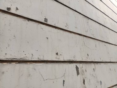 Duvarlar beyaza boyanmış ama boya soyulmaya başlamış ve çatlamış gibi görünüyor.