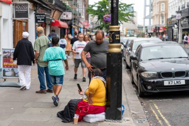 Londra, İngiltere - 30 Temmuz 2022: Turistler arasındaki dilenciler