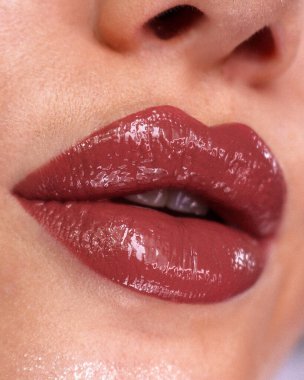 Şeftali rengi bir gölgede genç bir kadının dudaklarında kalıcı makyaj. 