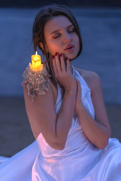 Beautiful woman with candles near lake