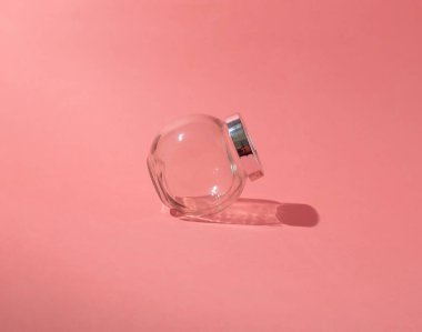 Boş cam kavanoz. Yaratıcı pembe arka plan. Düz yatış, üst görünüm.