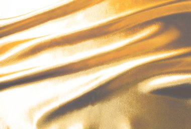 Pürüzsüz altın rengi ipek ya da saten lüks kumaş dokusu soyut bir arkaplan olarak kullanılabilir. Lüks arka plan tasarımı duvar kağıdı. Retro biçimi