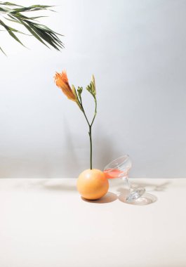 Yazın tropikal meyveler, çiçekler, yapraklar ve camdan oluşan yaratıcı bir düzen. Güneşli gün yemekleri konsepti.