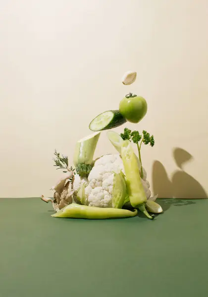 Creative still life of healthy organic food in shades of green color forming a sculpture. Right angle.