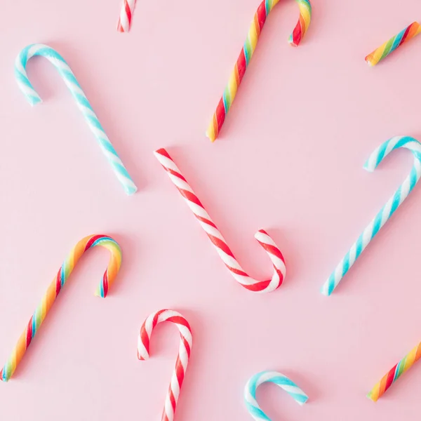 Creative minimal Christmas art. Pattern made with Christmas candies on pastel pink background. Flat lay. Copy space. Minimal composition.