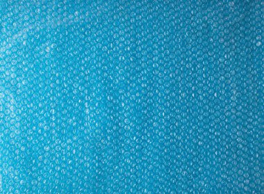 Kabarcık folyo dokusuyla mavi arkaplan. Moda yaratıcı fikir.