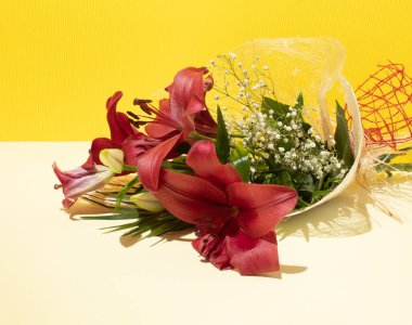 Sarı bir duvarın önündeki çiçek demetleri..